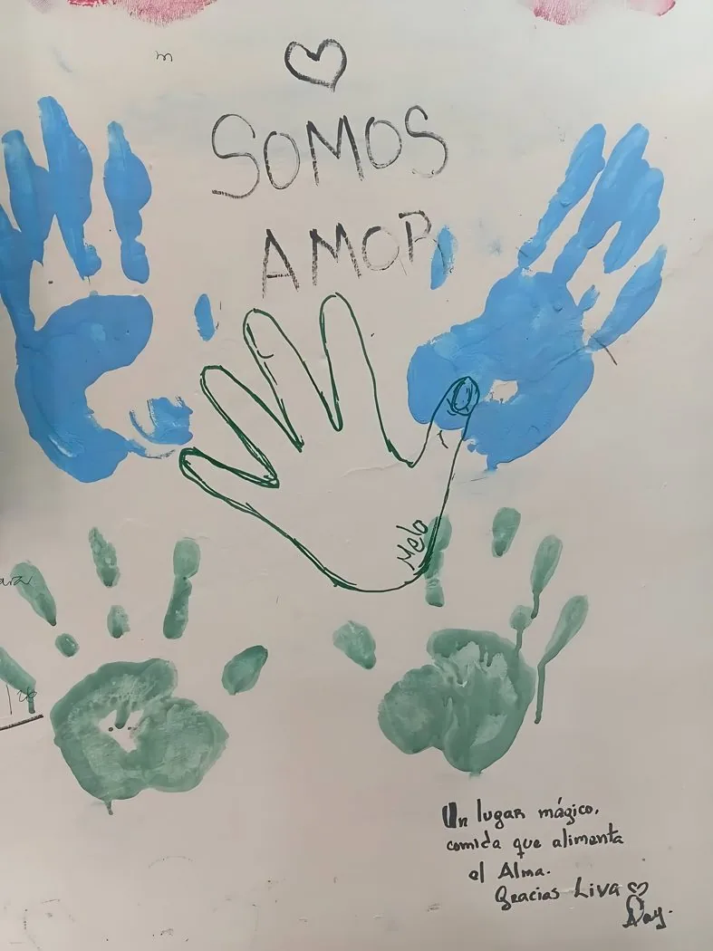 Mural de manos de colores con el mensaje SOMOS AMOR